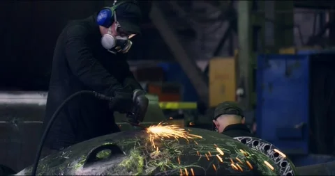 A professional worker in a protective mask works with a grinder in a factory Stock Footage 166026344