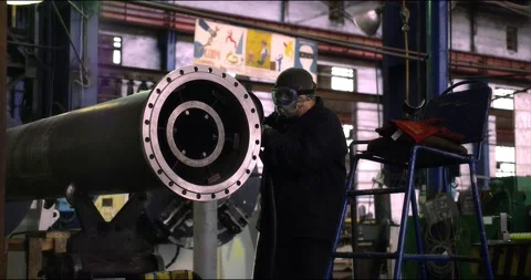 A professional worker in a protective mask works with a grinder in a factory Stock Footage 166148152