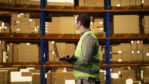 Professional worker reviewing inventory data in warehouse distribution hub Stock Footage 332908791