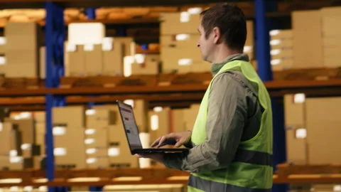 Professional worker reviewing inventory data in warehouse distribution hub Stock Footage 332911404
