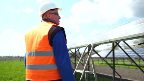 Professional worker at solar farm maintains the panels Stock Footage 168178346