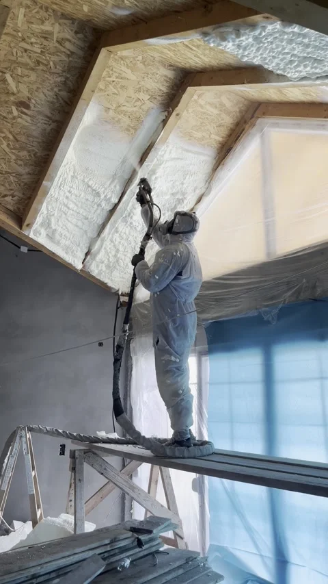 Professional worker spraying polyurethane foam insulation on ceiling Stock Footage 323409897