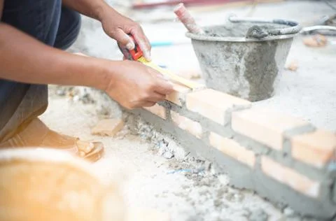 Professional worker using pan knife for building brick walls with cement and  Stock Photos