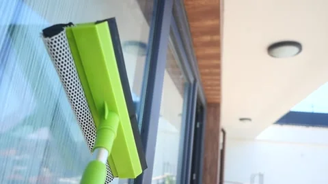 Professional worker washing windows with squeegee and scrubber tool on a su.. Stock-Footage 332579153