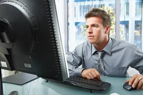 Professional working on computer Elegant professional businessman working ... Stock Photos