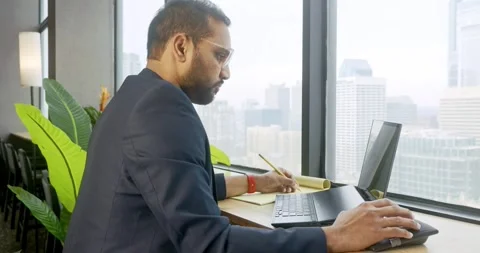 Professional working at desk with city view Stock Footage 325829455