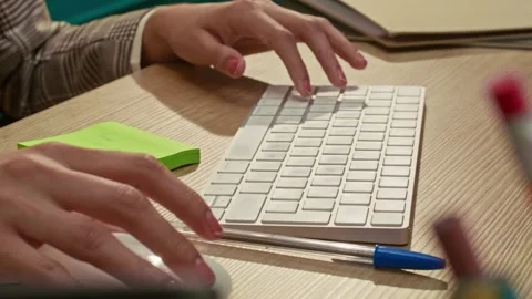 Professional working at a desk using a computer mouse with a green sticky Stock Footage 339400859