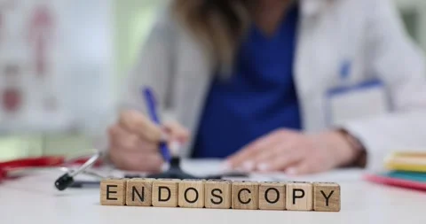 Professional works at desk with word Endoscopy on wooden blocks Stock Footage 313294060