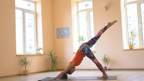 A professional yoga instructor demonstrates a set of healing efforts to Stock Footage 82073543