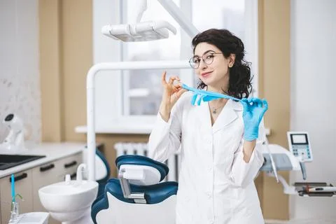 Professional young dentist posing beside modern equipment in a dental clinic. 库存照片