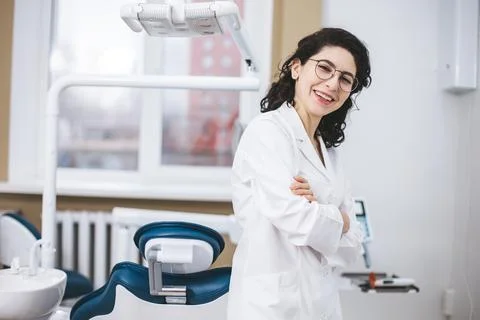 Professional young dentist posing beside modern equipment in a dental clinic. Photos