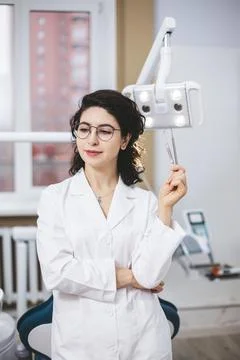 Professional young dentist posing beside modern equipment in a dental clinic. 库存照片