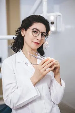 Professional young dentist posing beside modern equipment in a dental clinic. 库存照片