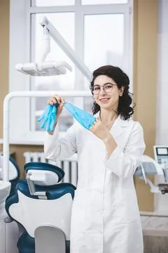 Professional young dentist posing beside modern equipment in a dental clinic. Stockfoto's