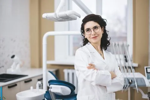 Professional young dentist posing beside modern equipment in a dental clinic. 库存照片