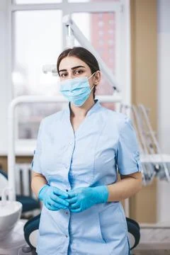 Professional young dentist posing in clinic office. Stock Photos