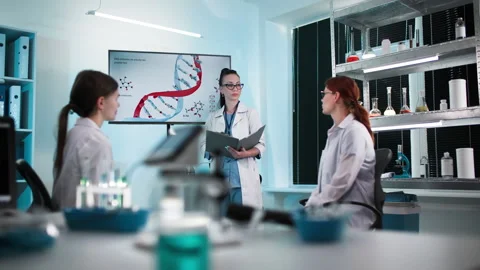 Professional young female lab technicians in medical uniforms study modern Stock Footage 307338235