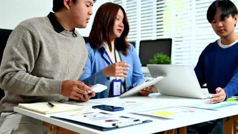 Professionals analyzing data and reports in office setting with tablet, cal.. Stock Footage 312775338