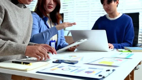 Professionals analyzing data and reports in office setting with tablet, cal.. Stock Footage 312775340