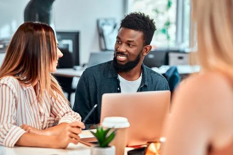 Professionals creating new project. Multiethnic business team using tablet at Stock Photos