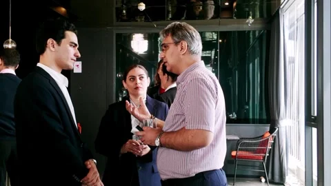 Professionals network at corporate reception, smiling and chatting with drinks Stock Footage 319814599