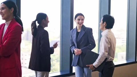Professionals networking in a modern office by large windows, chatting in s.. Video stock 345518720