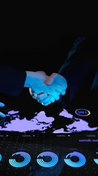 Professionals shaking hands over interactive digital table displaying global map Stock Photos