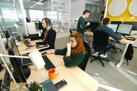 Professionals working on desktop computers in open plan office Foto stock