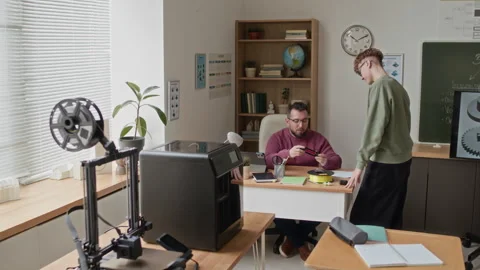 Professor and Student Discussing Printed Part in 3D Modeling Classroom Stock Footage 335690566