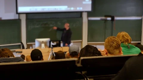 Professor or teacher delivers a lecture college to a large audience of students Stock Footage