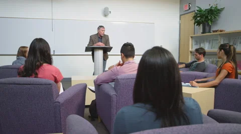 A professor speaking to his students in a study room Stock Footage 55100146