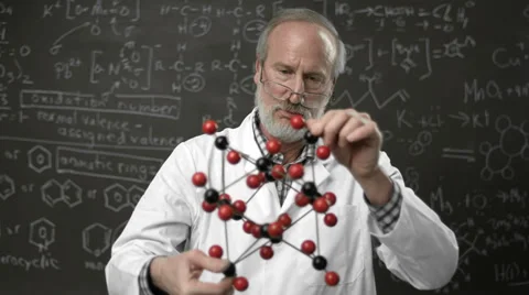 A professor stands in front of a blackboard of a model of a chemical molecule Stock Footage 33881871