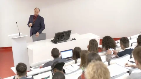 Professor teaching many college students in the auditorium Stock Footage 69929827