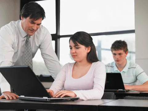 Professor Teaching Students In Computer Class Stock Photos