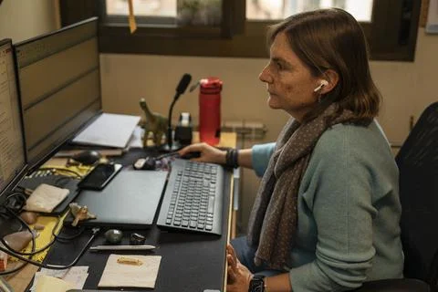 Professor working from home using dual monitor and wireless earphones Stock Photos