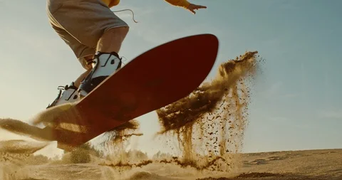 Proffesional sandboarder jumping at sunset Stock Footage 115542471