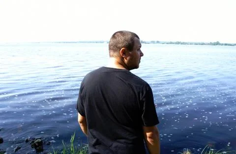 Profile of bearded man on river background. Young guy enjoying breathing fres Stock Photos