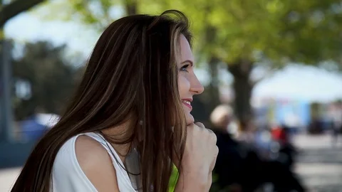 Profile of a Beautiful brown-haired woman,smiling at someone leaning on her hand Stock Footage 114263781