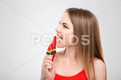 Profile of beautiful girl licking watermelon shaped lollypop Stock Photos