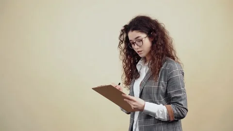 From the profile, a beautiful student holds a notebook in her hand and takes Stock Footage 150466845