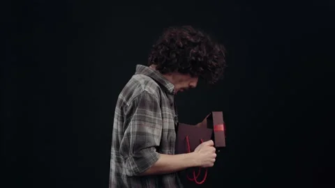 The profile of a boy with a gift in his hand, he opens it and shouts wow being Stock Footage 155087400