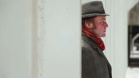 Profile close up of man with the hat coat red scarf in urban abandoned building Stock Footage 48013387