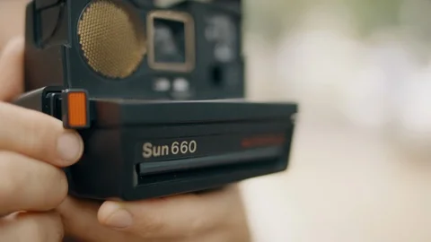 Profile close up shot of a person using an old Polaroid Sun 660 camera. Stock Footage