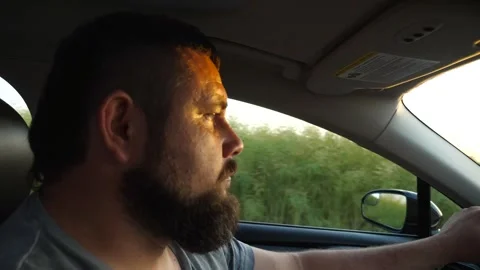 Profile of confident man with beard driving a motor car at countryside. Driver Stock Footage 297362185
