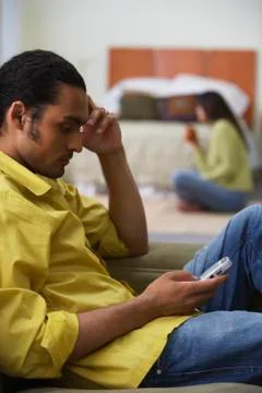 Profile of couple in bedroom working separately Stock Photos