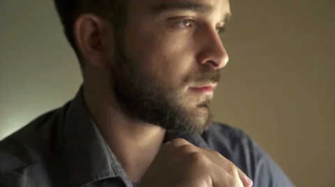 Profile of guy with beard reflecting, resting his face on his hand Stock Footage 68341034