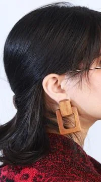 Profile image of model wearing large handmade wooden earrings Stock Photos