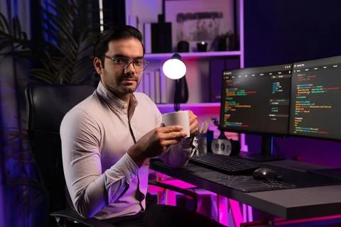 Profile IT looking camera holding coffee cup at neon cyber office. Surmise. Stock-Fotos