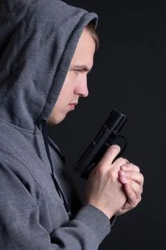 Profile of man criminal with gun over grey Stock Photos