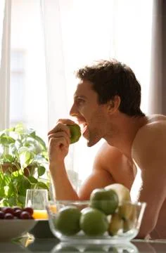 Profile of man eating apple Stock Photos